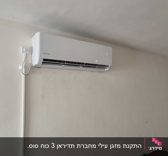 מזגן מותקן על קיר עם חיבור לחשמל